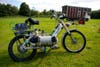 A moped powered by compressed air, standing in a grass field.