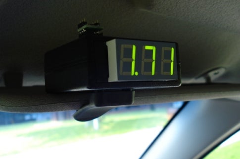 A meter clipped to a visor in the front of a car that reads 1.71.
