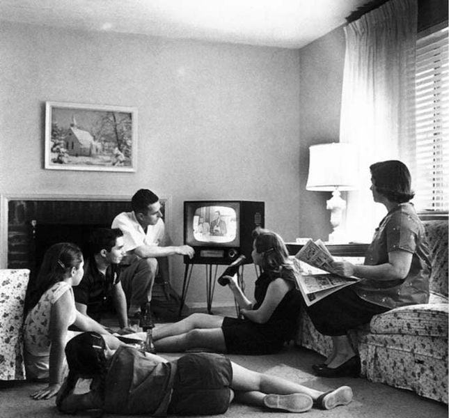black-and-white photo showing a family watching TV in 1958