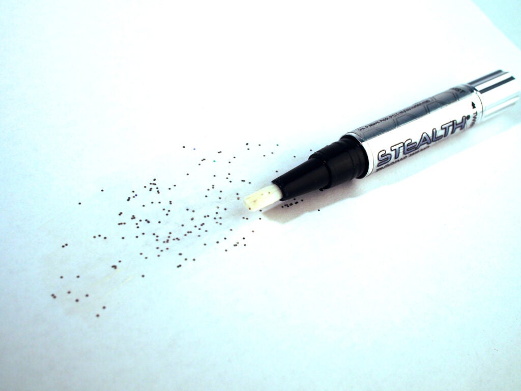 An adhesive pen with a bunch of tiny dots in the background
