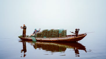 Chinese man shrimp fishing from his boat at Lake Hong