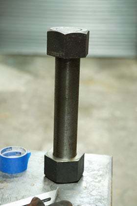 A steel bolt leg that looks like a vertical dumbbell.