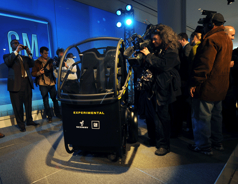 The Project P.U.M.A. electric two-seat prototype vehicle with just two wheels is photographed by media after its unveiling Tuesday, April 7, 2009 in New York.