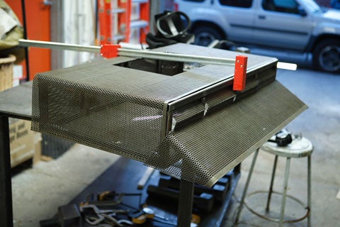 A steel box that will house an arcade box, in a garage.