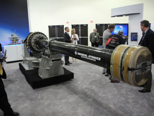 This is a railgun. General Atomics spent years working on this. It shoots projectiles at a flat trajectory up to 200 nautical miles at tremendous speed, guaranteeing a bad day for someone very far away. <a href="http://www.ga.com/docs/defense/Blitzer-brochure.pdf/">Displays nearby</a> highlighted its defensive potential, especially as part of missile defense.