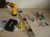 A power drill, a level, other tools, and a sheet of plywood.