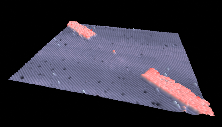 A scanning tunneling microscope image of a hydrogenated silicon surface shows a 3-D perspective of a single-atom transistor. The red-shaded regions form the electrical leads to a single phosphorus atom in the center.