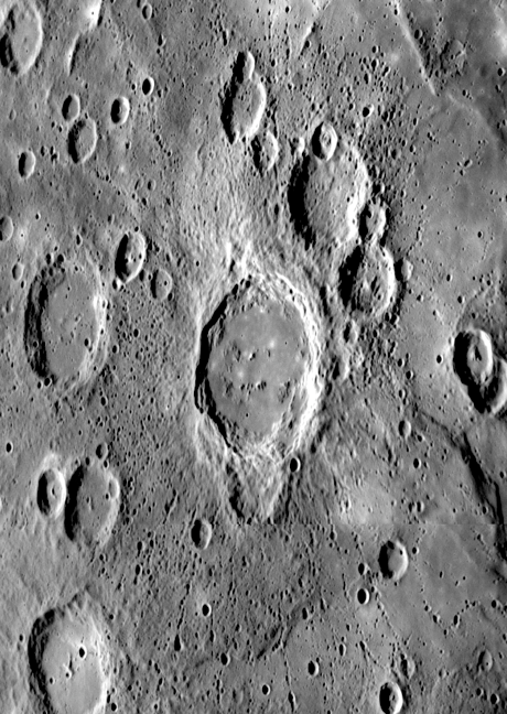 This newly observed flat-floored crater was viewed at an oblique angle as <em>Messenger</em> approached Mercury for its third flyby. The distinctive halo of small secondary craters that radiate outward from the central structure shows that this crater is younger than nearby craters of similar size. Many of these secondaries are aligned in chain-like formations and some show characteristic "herringbone" features pointing back to the crater of origin. This unnamed crater is partially superposed on an older and smaller crater to the south.