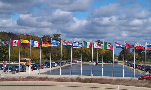 The flags that represent the nations conducting research at the lab fly in front of Fermilab.