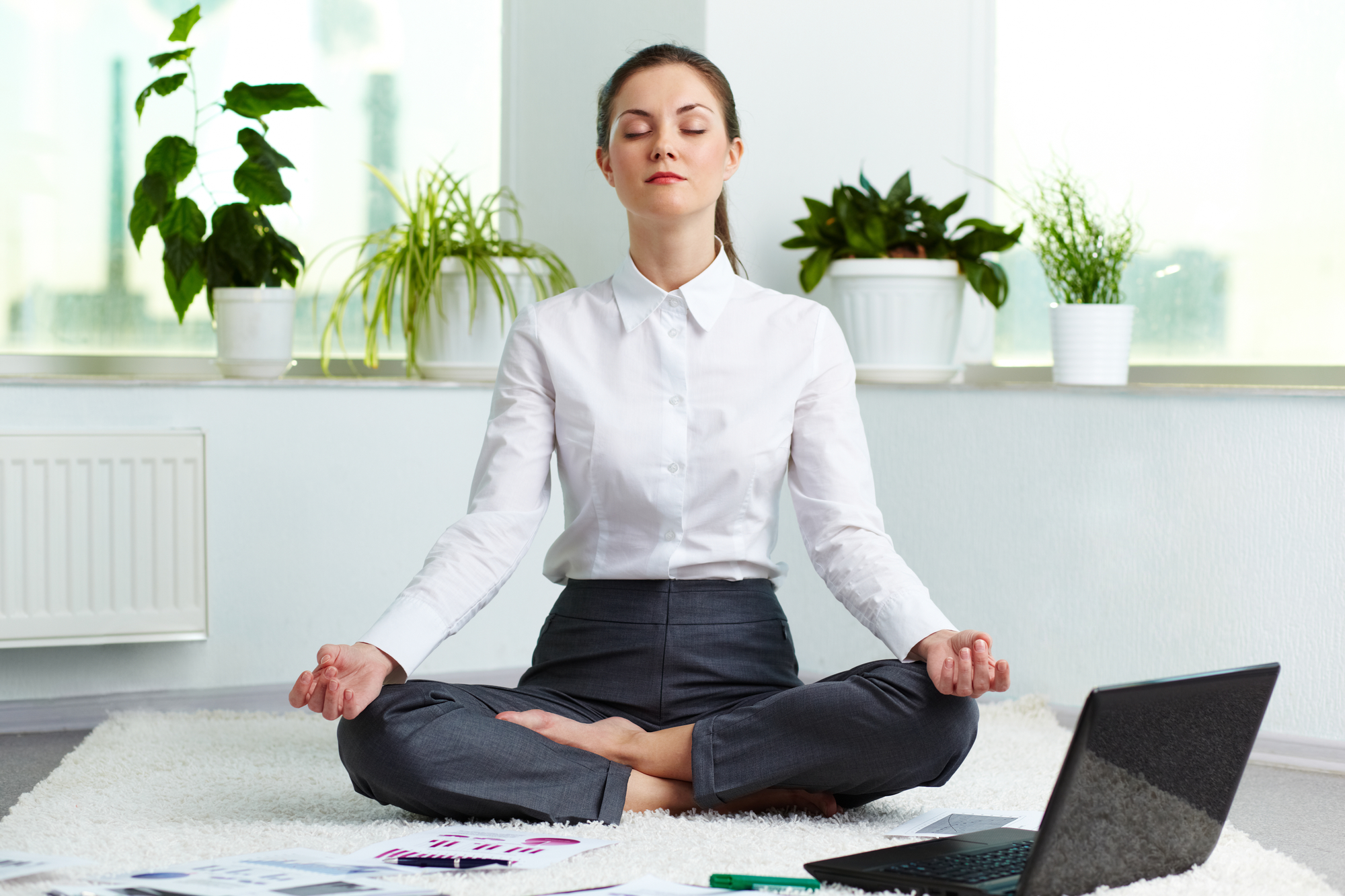 Portrait of attractive white collar worker meditating in office