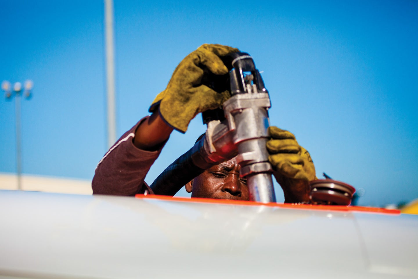 man pumping fuel into airplane