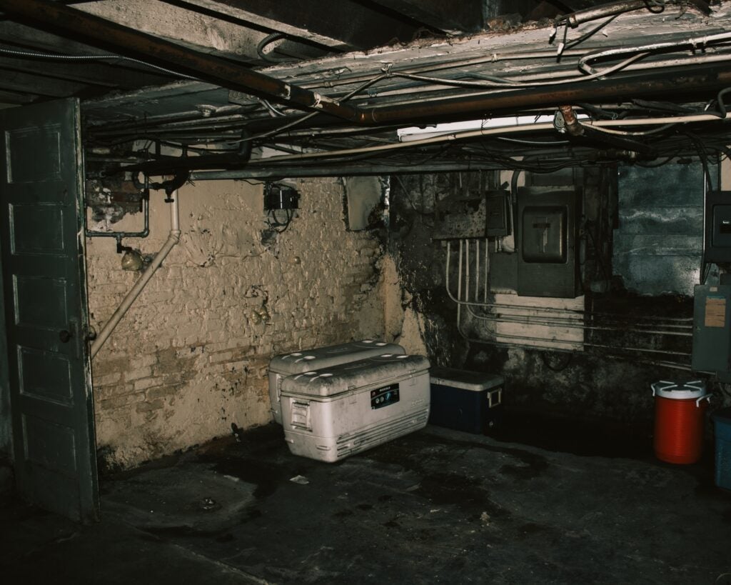 a dark, creepy basement with some coolers in it