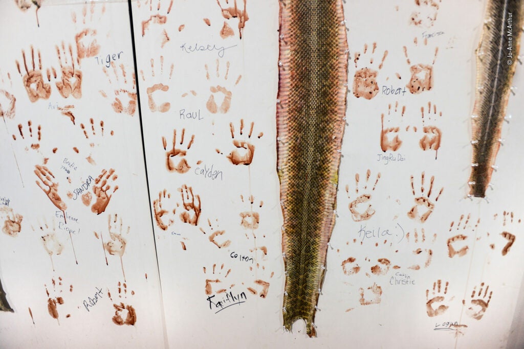 Bloody handprints on a wall next to a tacked-up rattlesnake skin