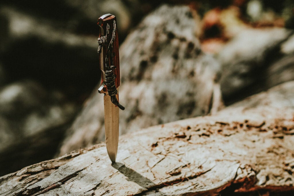 knife blade stuck in a wooden log