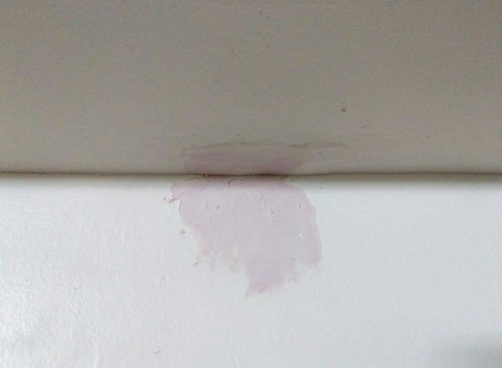 a hole in drywall covered and repaired with putty