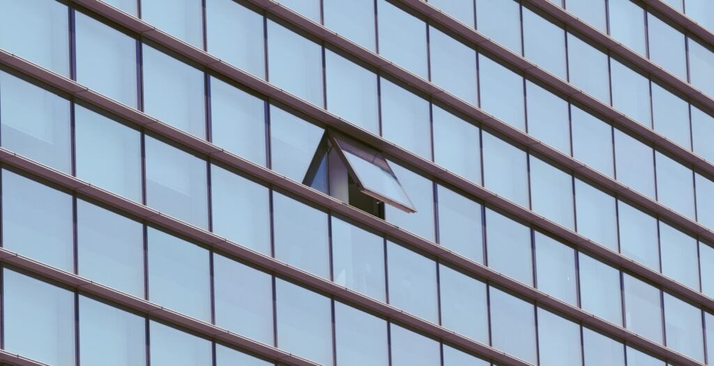 nowoczesny szklany budynek z jednym oknem otwartym
