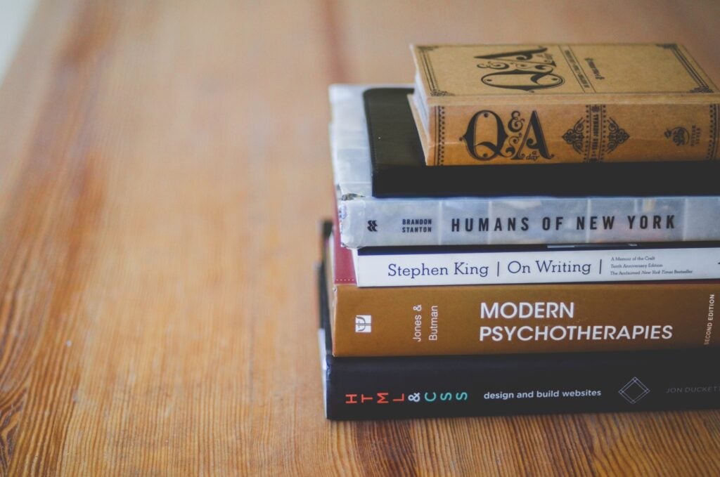 a stack of books on a wood surface