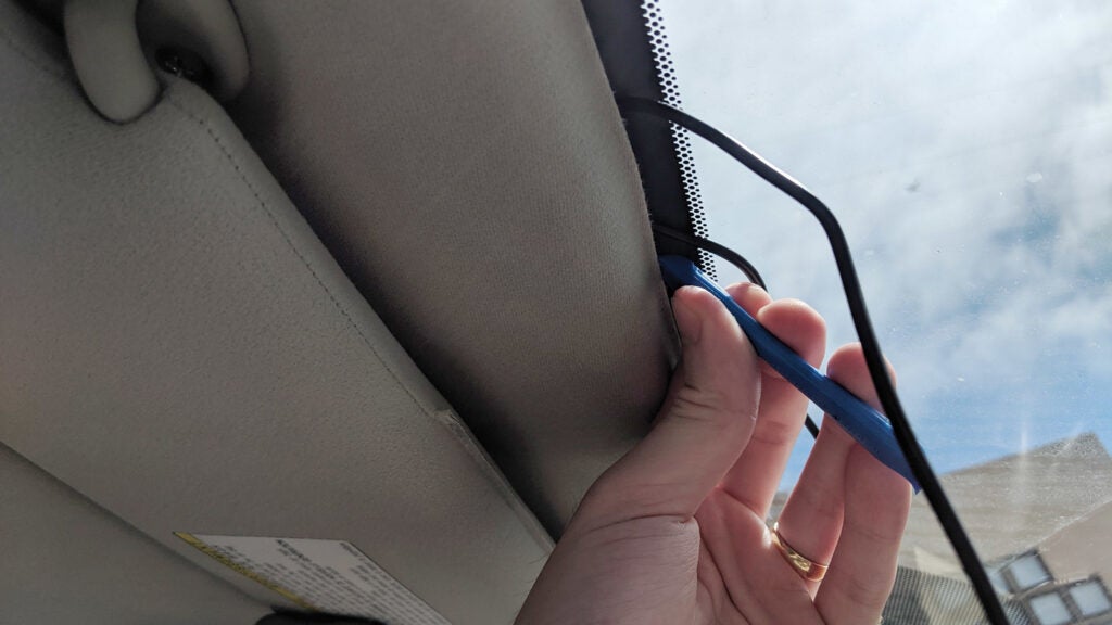 hand laying a cable in a windshield