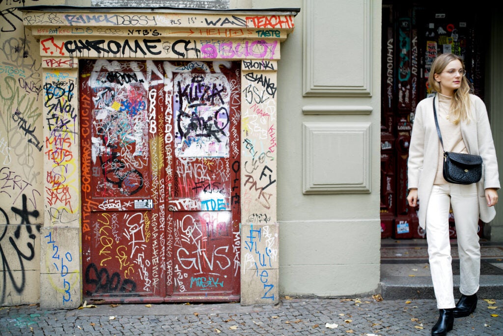 red door with graffiti and woman in white