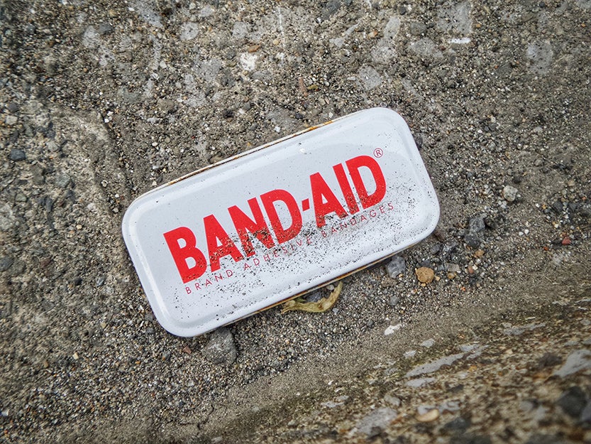band-aid container on ground