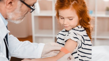 child getting a vaccine by her doctor