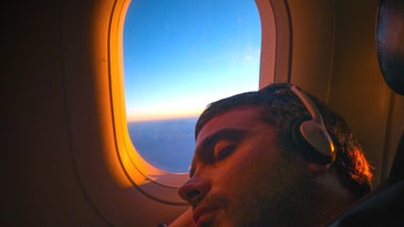 Person sleeping on plane with open window