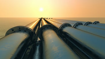 gas pipeline across snowy landscape at sunset