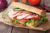 Submarine sandwich with smoked ham, tomato and rocket salad