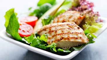 closeup of healthy salad with grilled chicken fillet, selection of lettuce, tomatoes and avocado,