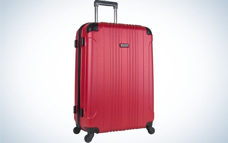 Red luggage with 4 wheel spinners with top black grab handle standing upright from front.