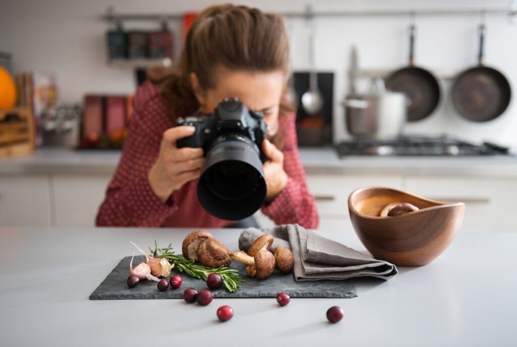 A photographer taking a close-up of food in a kitchen