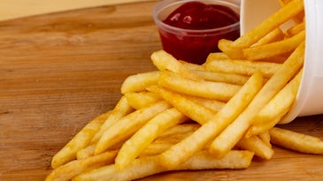 a pile of french fries and a bowl of ketchup
