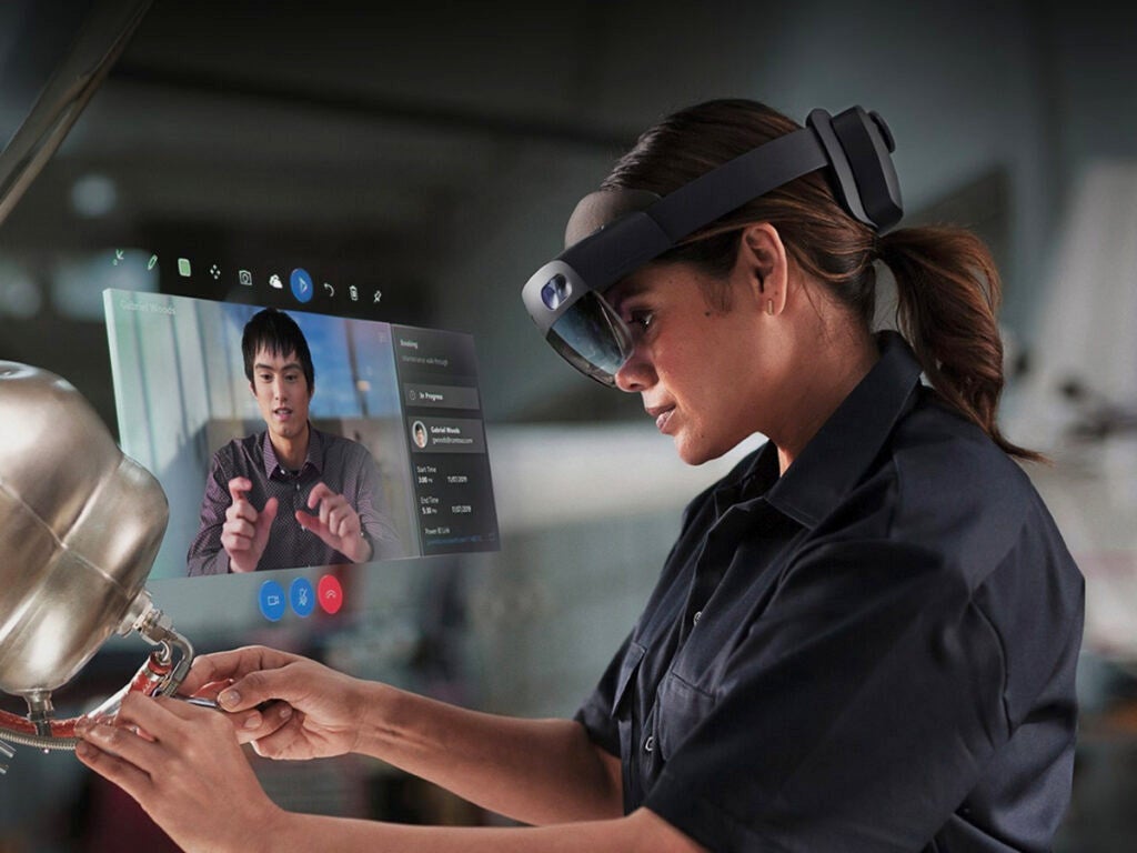 a person using the Microsoft HoloLens to put something together with an instructor