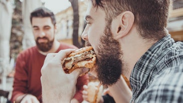 man eating fast food hamburger