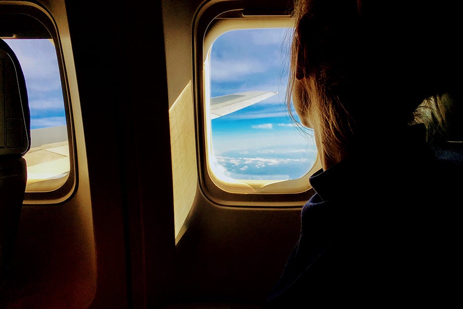 woman looking out a plane window
