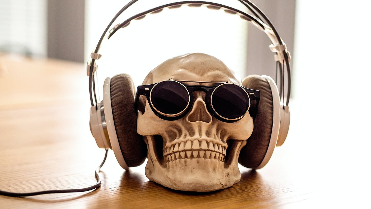 a human skull wearing sunglasses and large headphones
