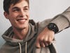a young man wearing a Fossil smartwatch and lifting up his sweatshirt