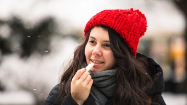 woman using cream at cold winter weather. skin protection. dry face