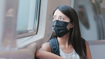 a woman wears a black face mask on the train in Taipei city in taiwan