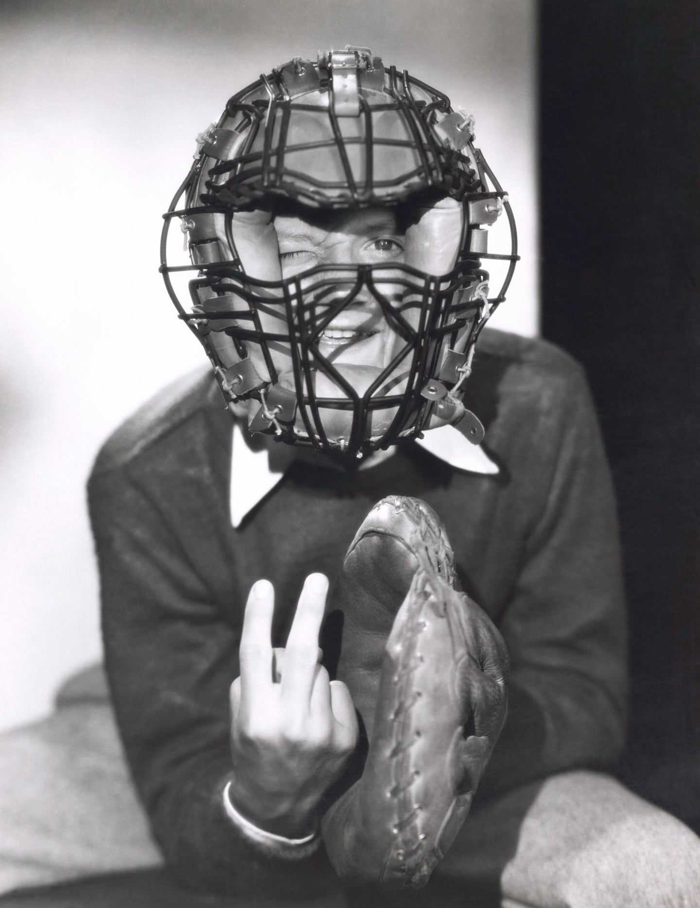 An old-school catcher throwing up a pitch sign