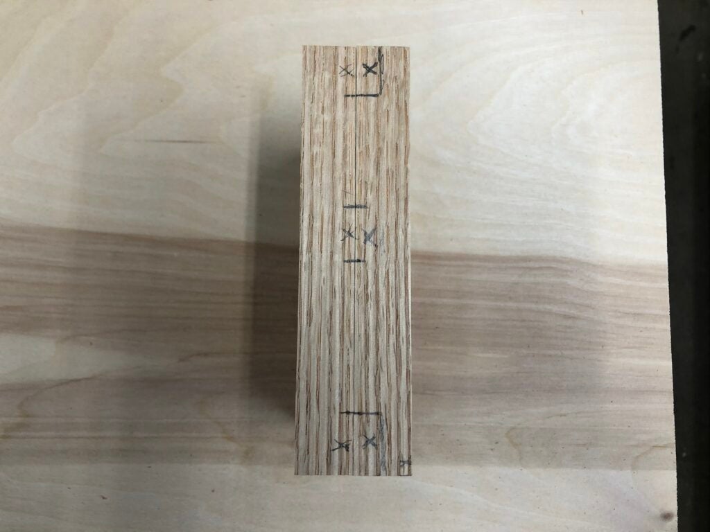 two pieces of oak for the vertical sides of a shelf key cabinet, marked for where to cut dado and rabbet joints