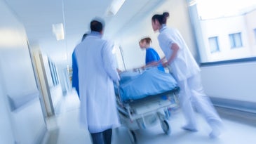 a blurred shot of hospital workers wheeling a gurney