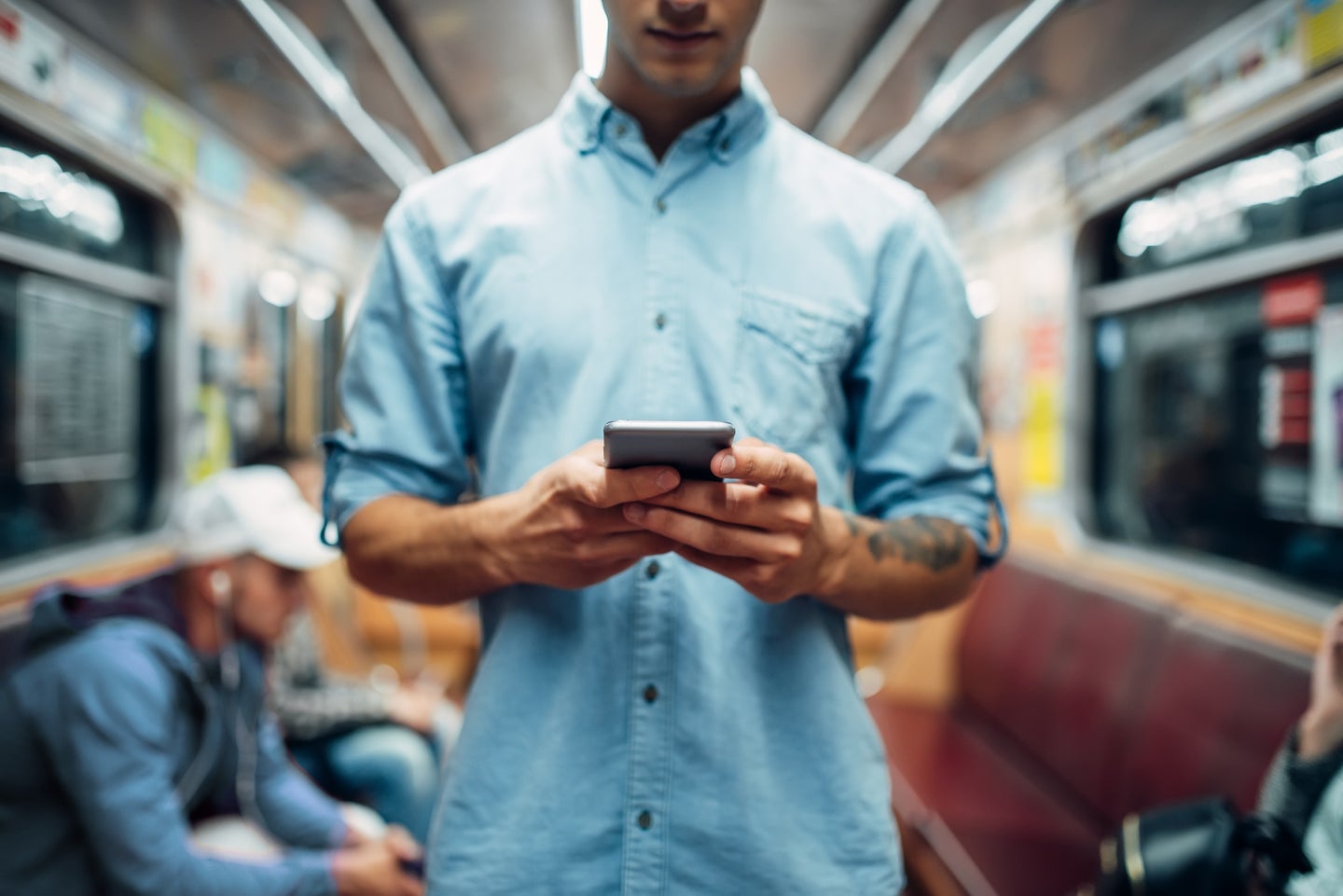 a man holds a phone in his hands on the subway