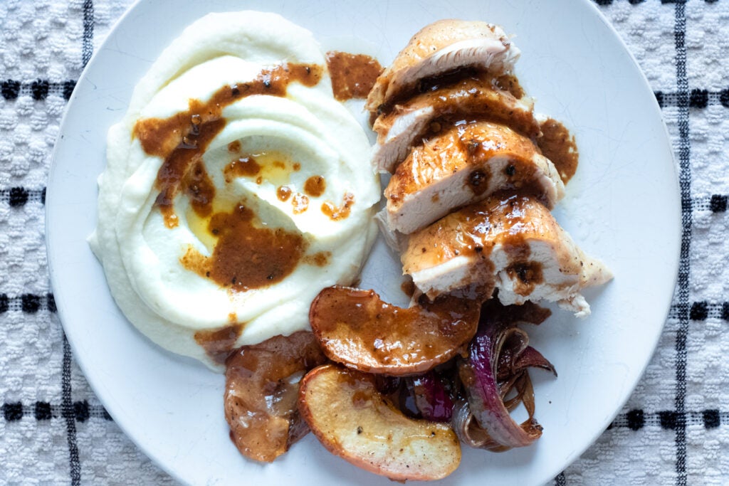 Dish of roasted chicken, apples and mashed potatoes