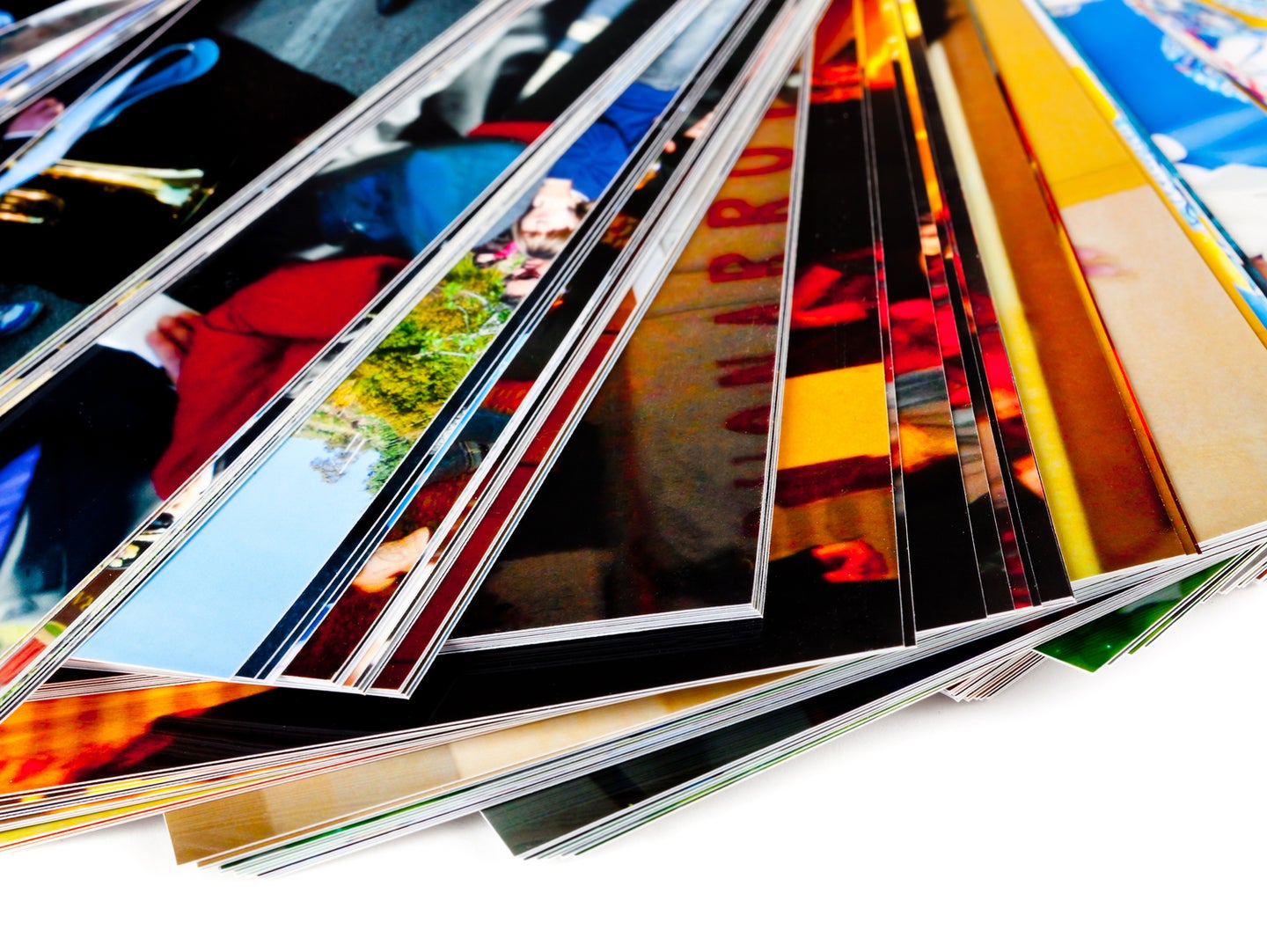 A fanned-out stack of printed photos on a white surface.