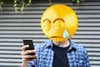 Emoji head man using a smartphone.