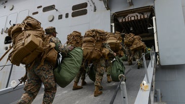 Marines board the amphibious assault ship USS Iwo Jima