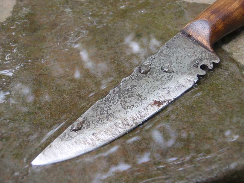 A knife being sharpened on a wet stone.