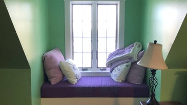 a cushioned window seat in a bedroom dormer window