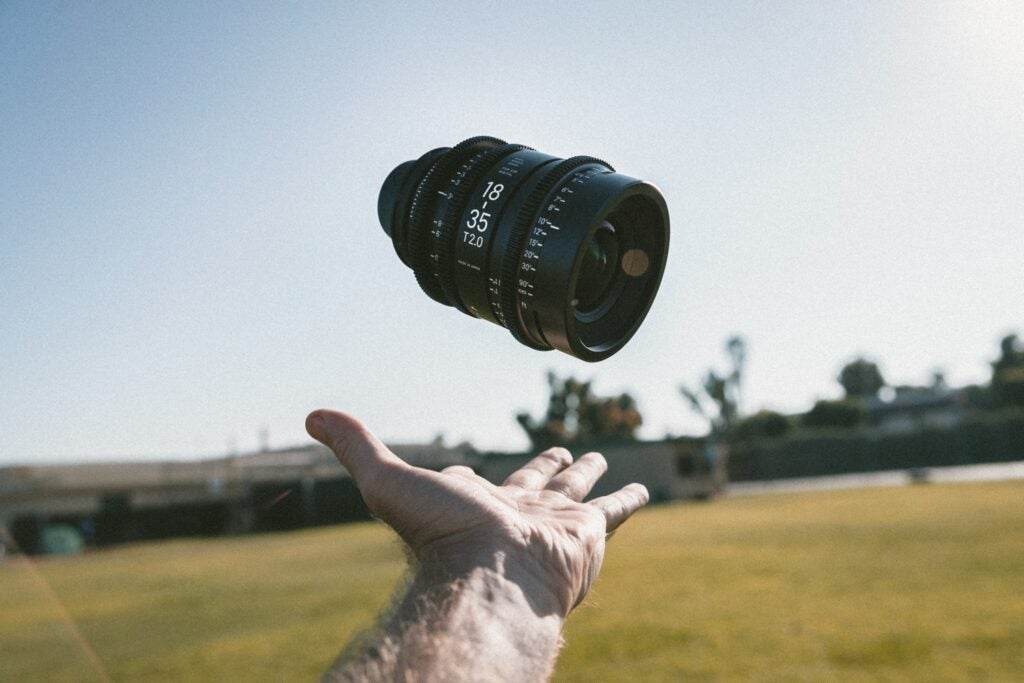 Hand throwing camera lens in the air